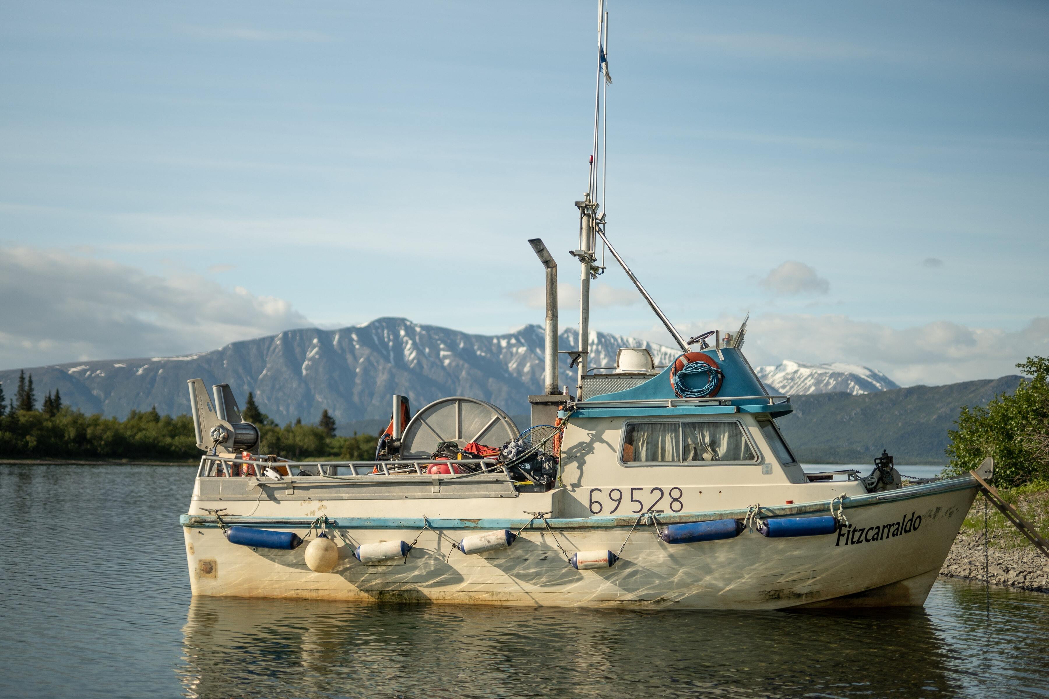Fishing boat in Alaska with mountain backdrop